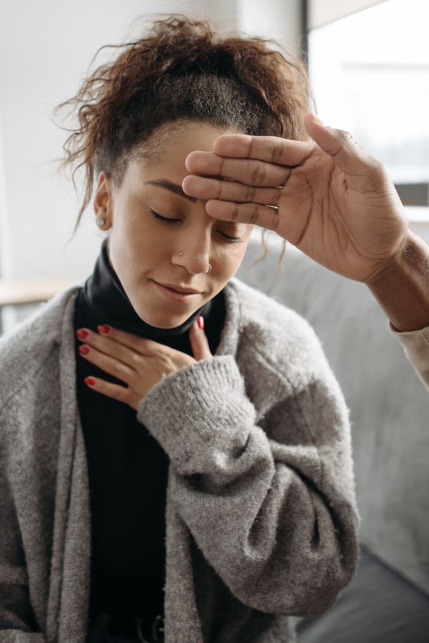 A woman being checked for fever, demonstrating health care at home.