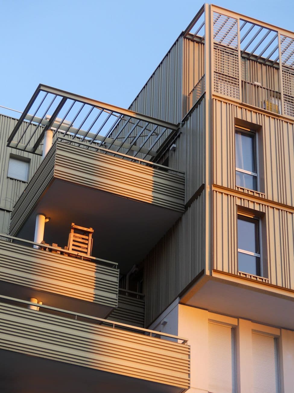 Contemporary balconies of a modern building in Montpellier, France, illuminated by sunset.