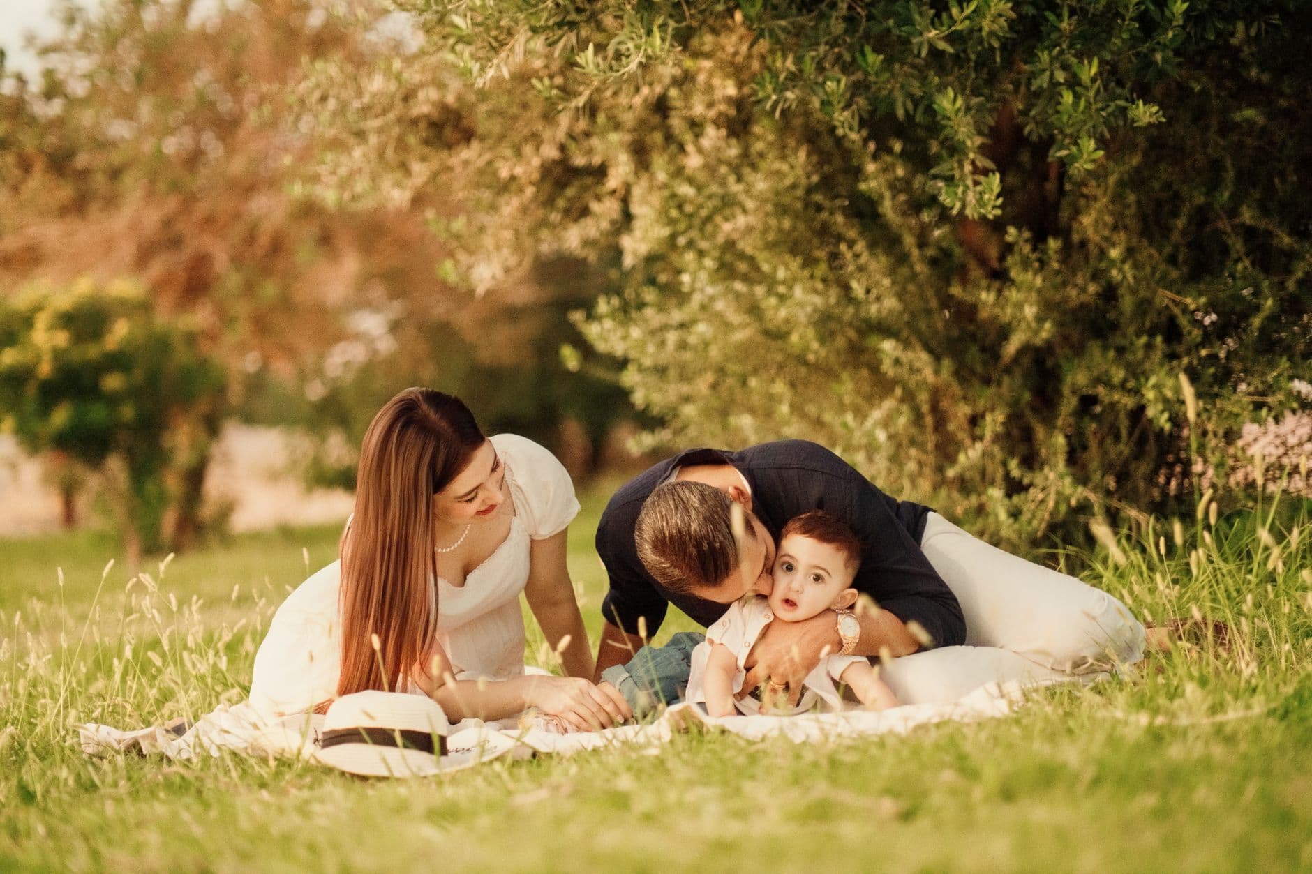 A happy family having a picnic in a lush green park setting during the day.