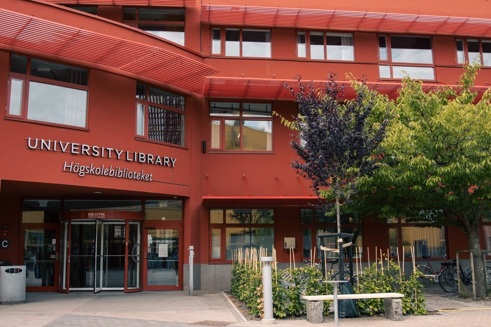 Entrance of the University Library in Jönköping with adjacent garden and trees.