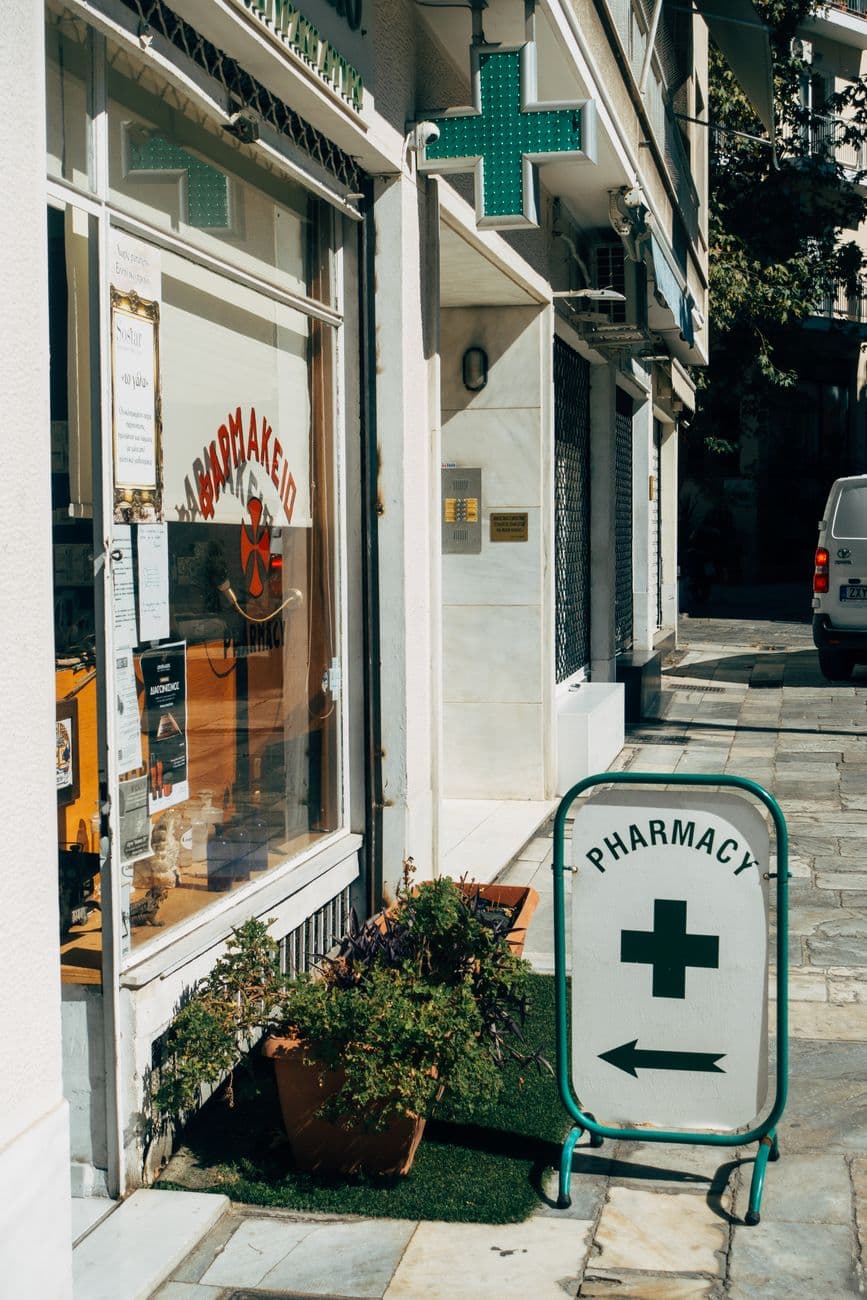 External view of a pharmacy with directional signage on a sunny day.