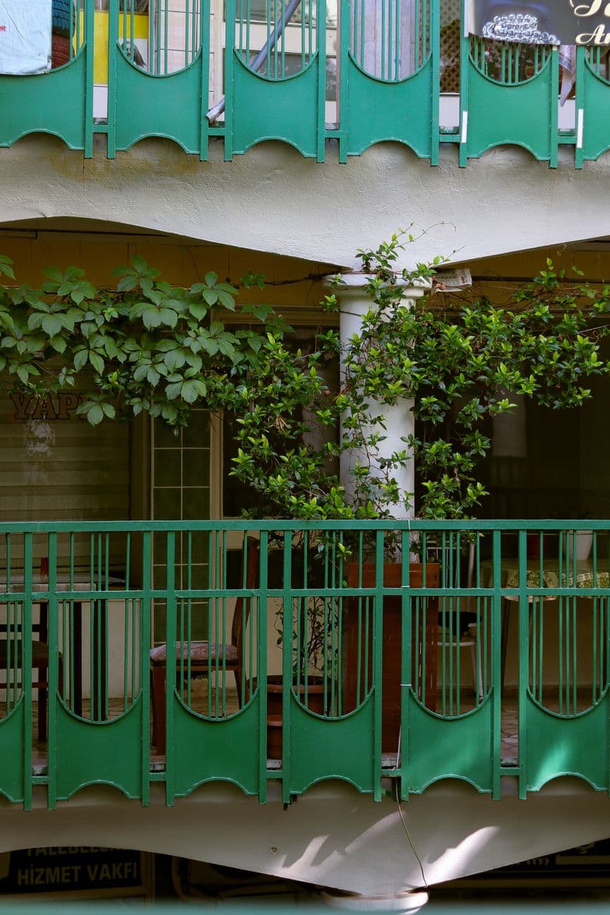 A vibrant urban scene of green balconies adorned with lush plants.