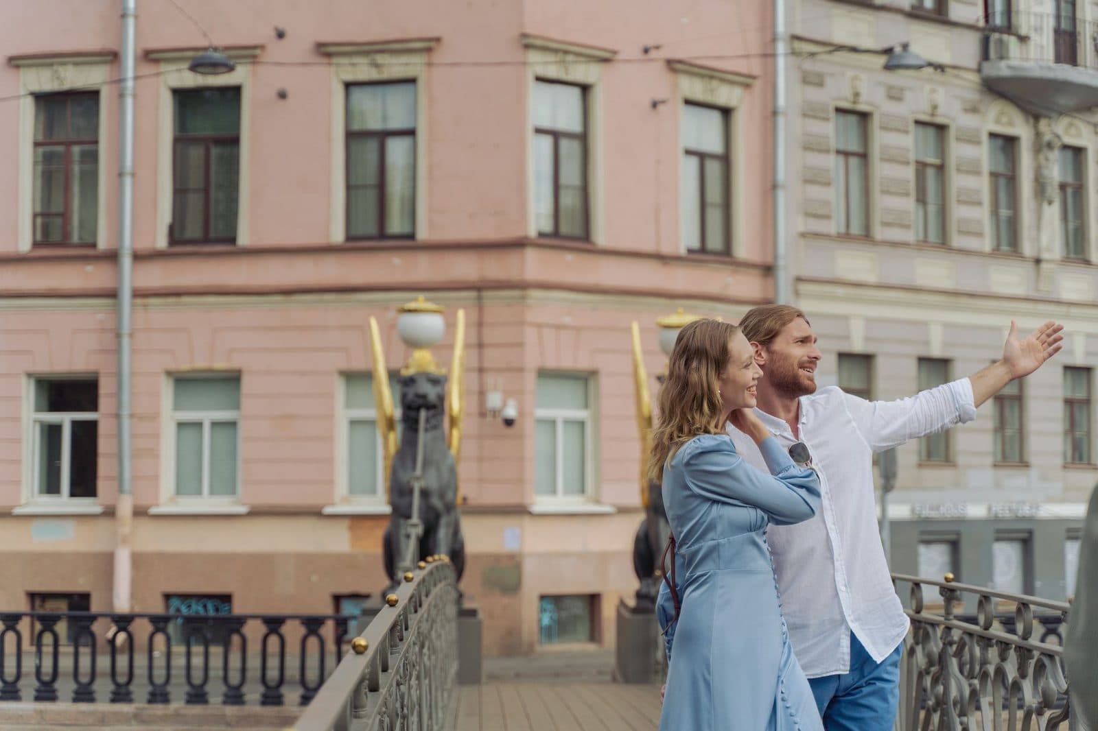 Happy couple exploring the city and enjoying a day out by a historic bridge.