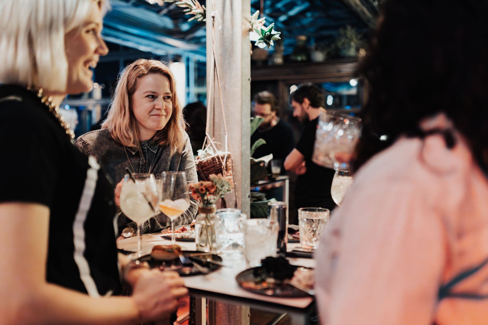 A social scene indoors at a bar with friends enjoying drinks and conversation.