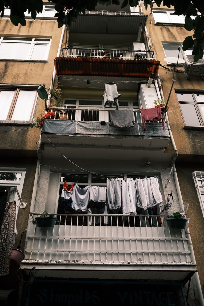 Low angle view of an apartment building with clotheslines on balconies.