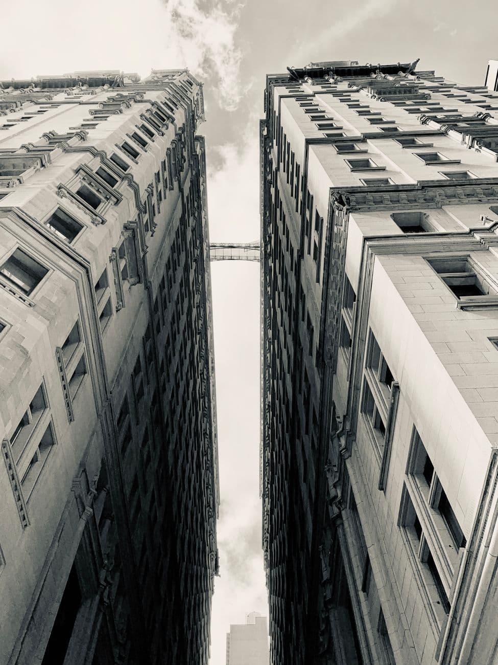 Monochrome view of New York's historic skyscrapers from a low angle, capturing urban architectural details.