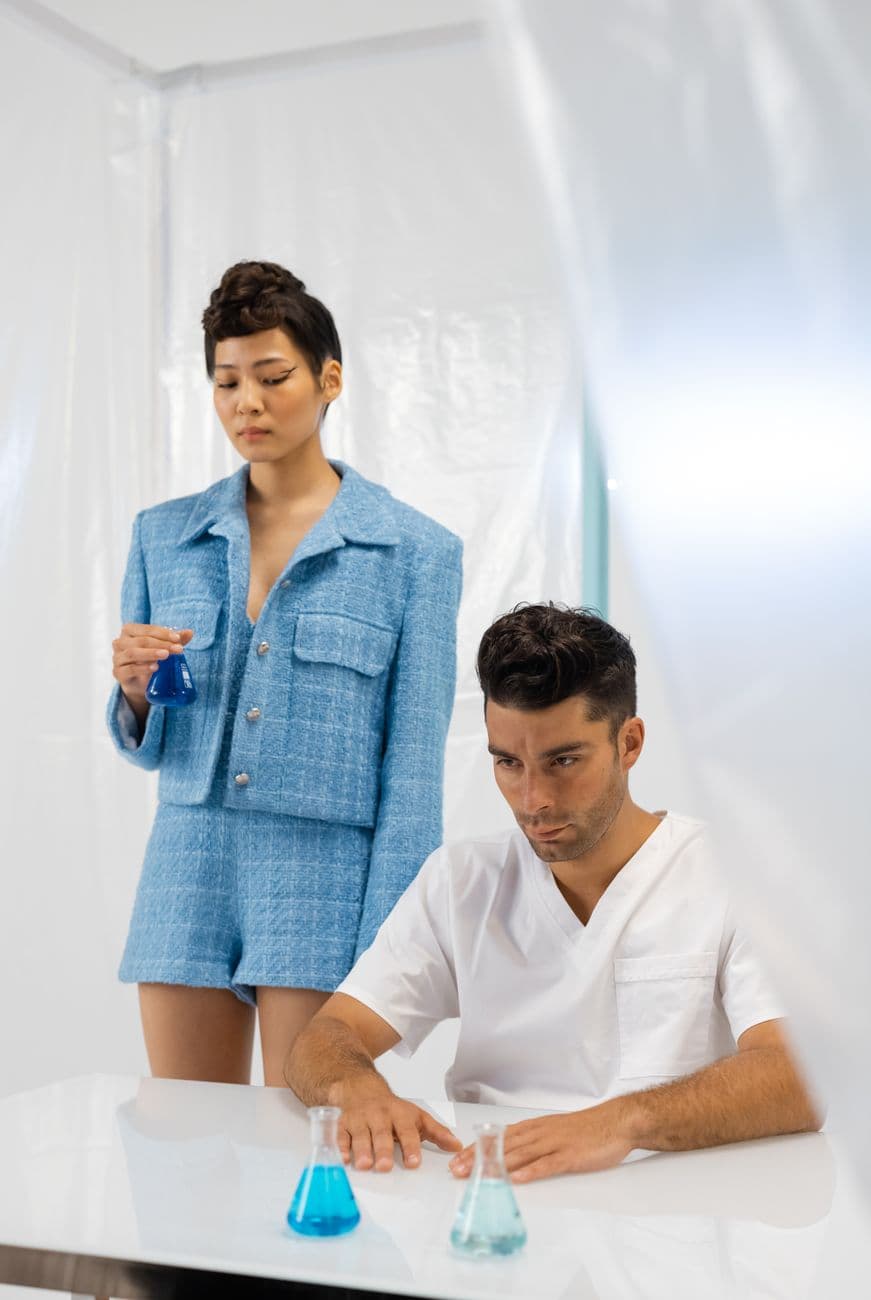 Two scientists conducting an experiment in a modern laboratory setting with vibrant blue chemicals.