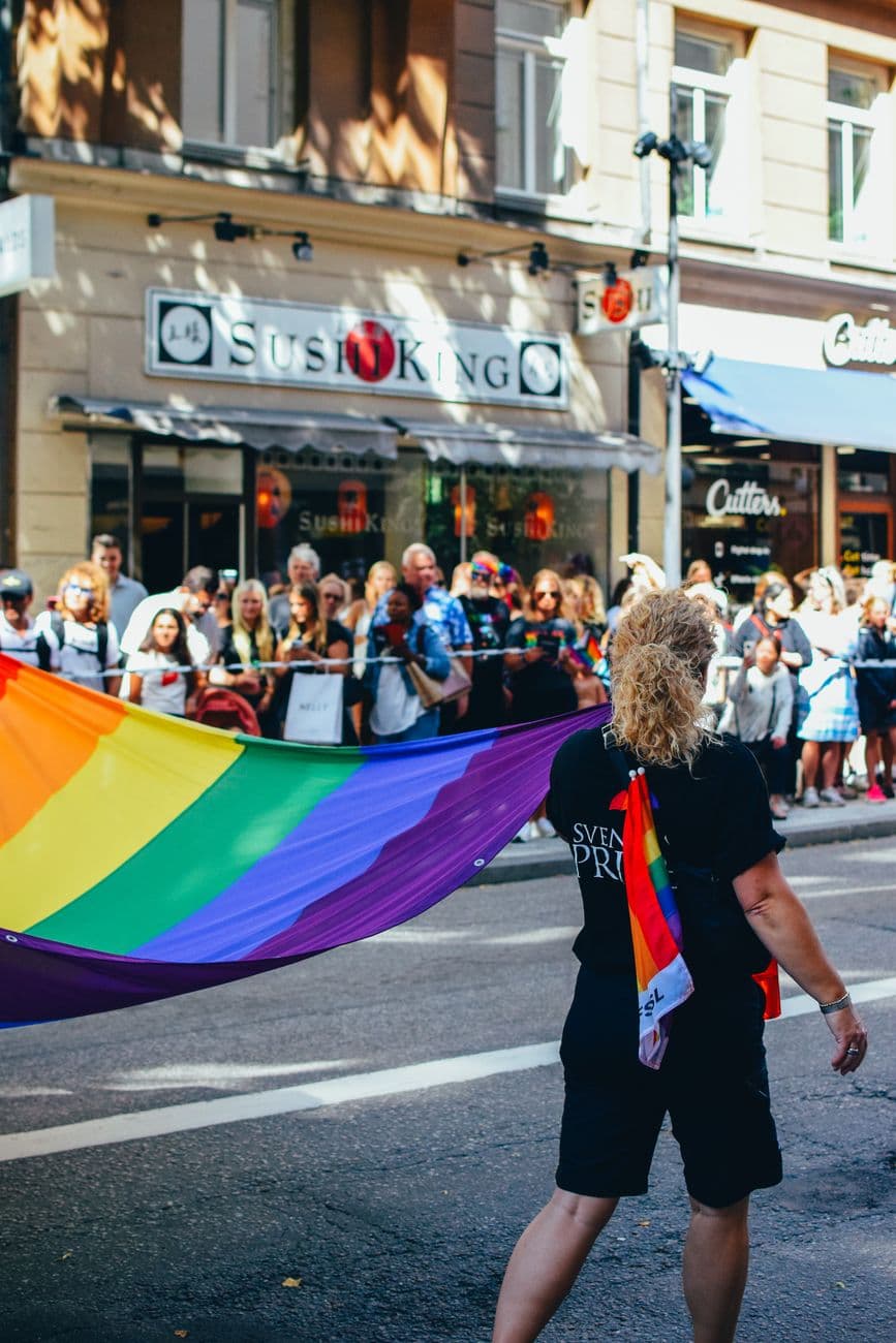 Colorful pride parade with rainbow flag in Stockholm, celebrating diversity and inclusion.