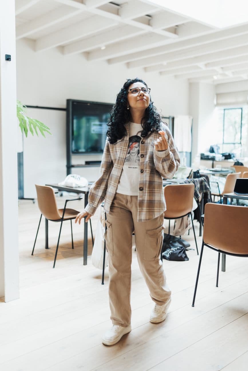 Casual dressed woman walking in a chic and modern office environment, embracing style and professionalism.