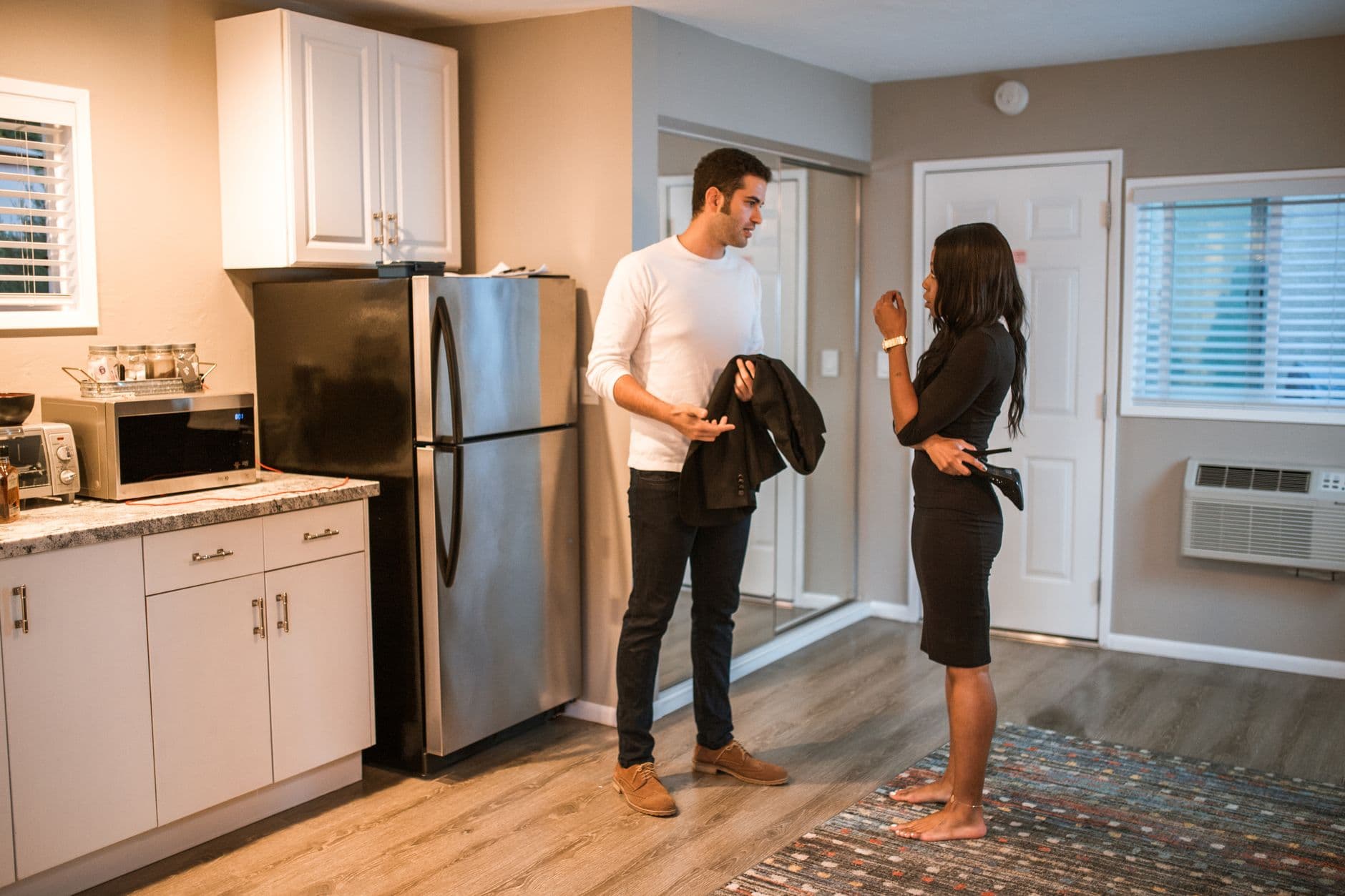 A couple having a serious conversation in a stylish kitchen setting.