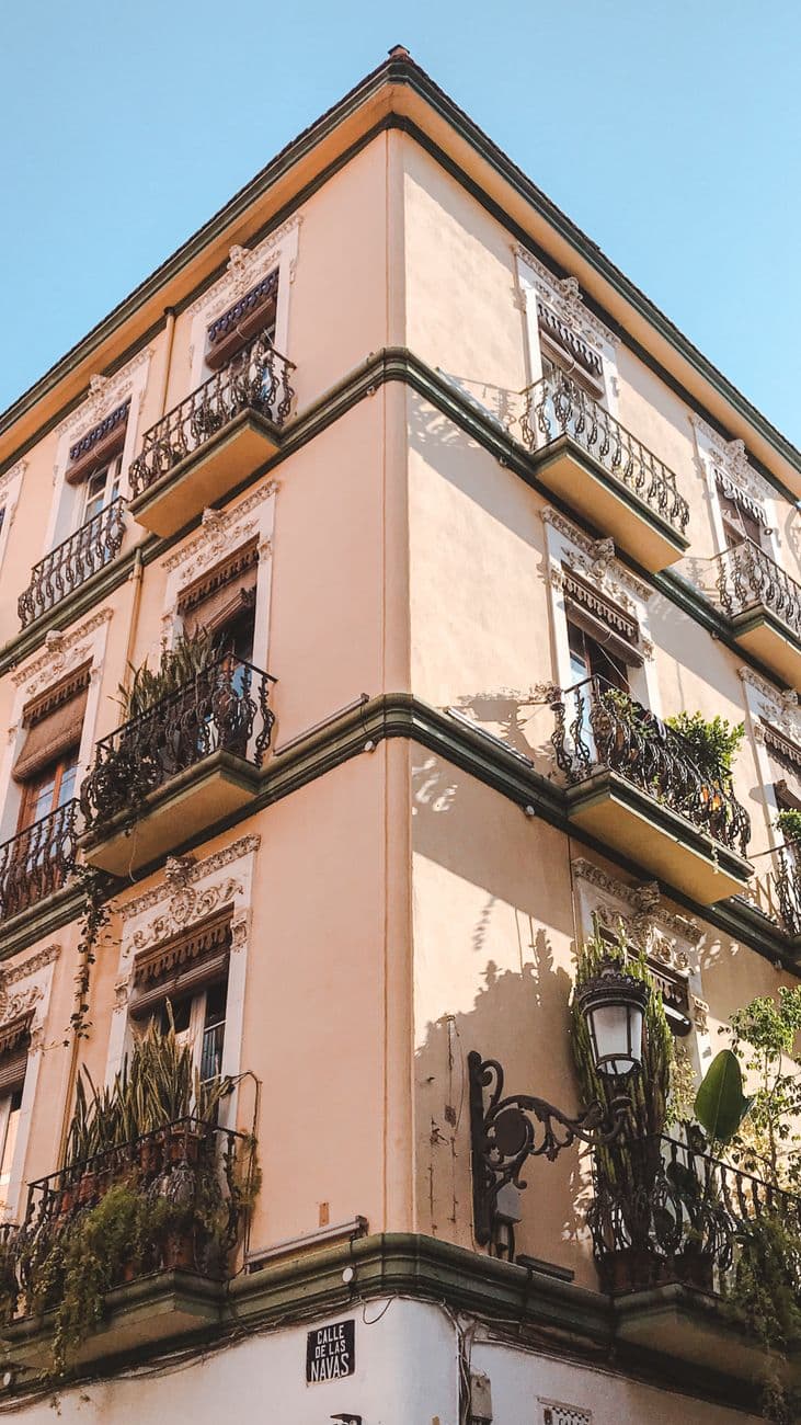 A picturesque corner view of a classic Mediterranean style apartment building with balconies.