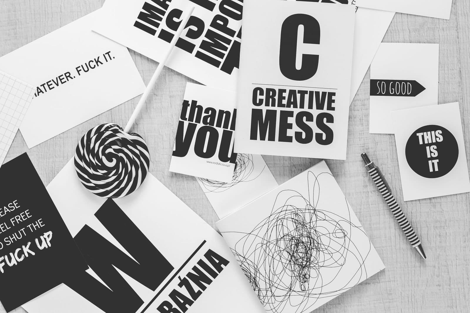 Monochrome desk scene with creative typography, candies, and a striped pen.