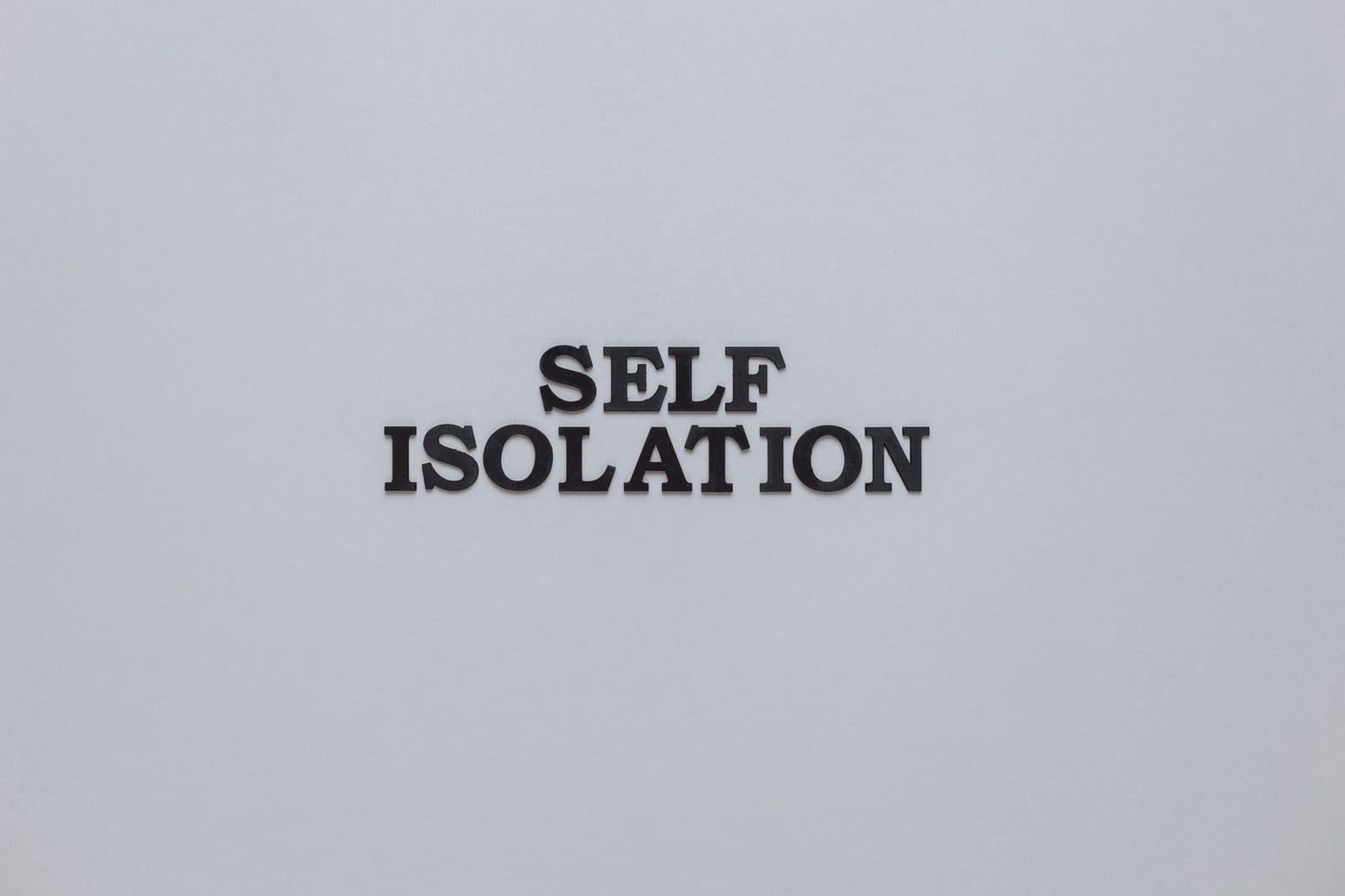 Black text 'SELF ISOLATION' on white background symbolizing isolation theme