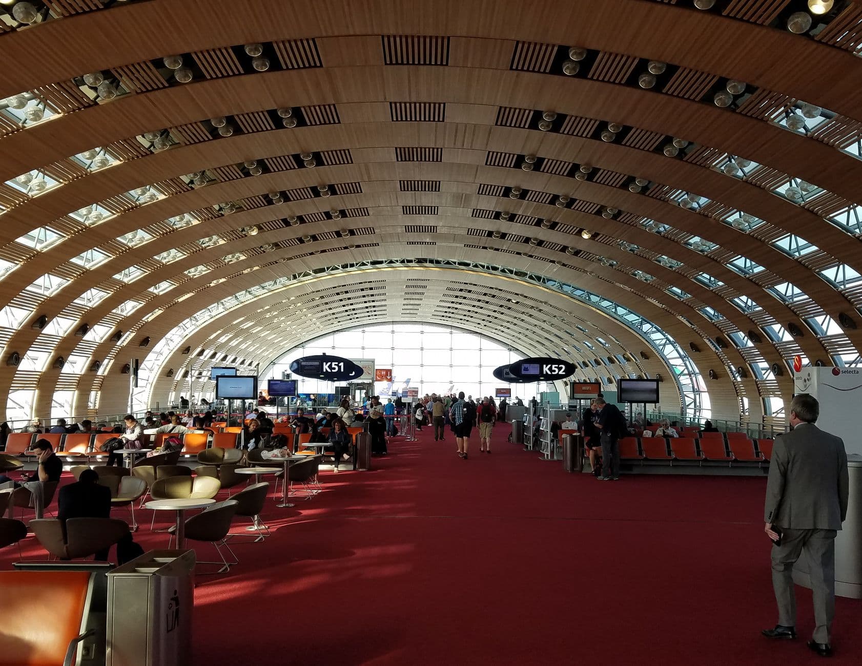 Travelers in the modern, spacious terminal of Charles de Gaulle Airport, Paris.