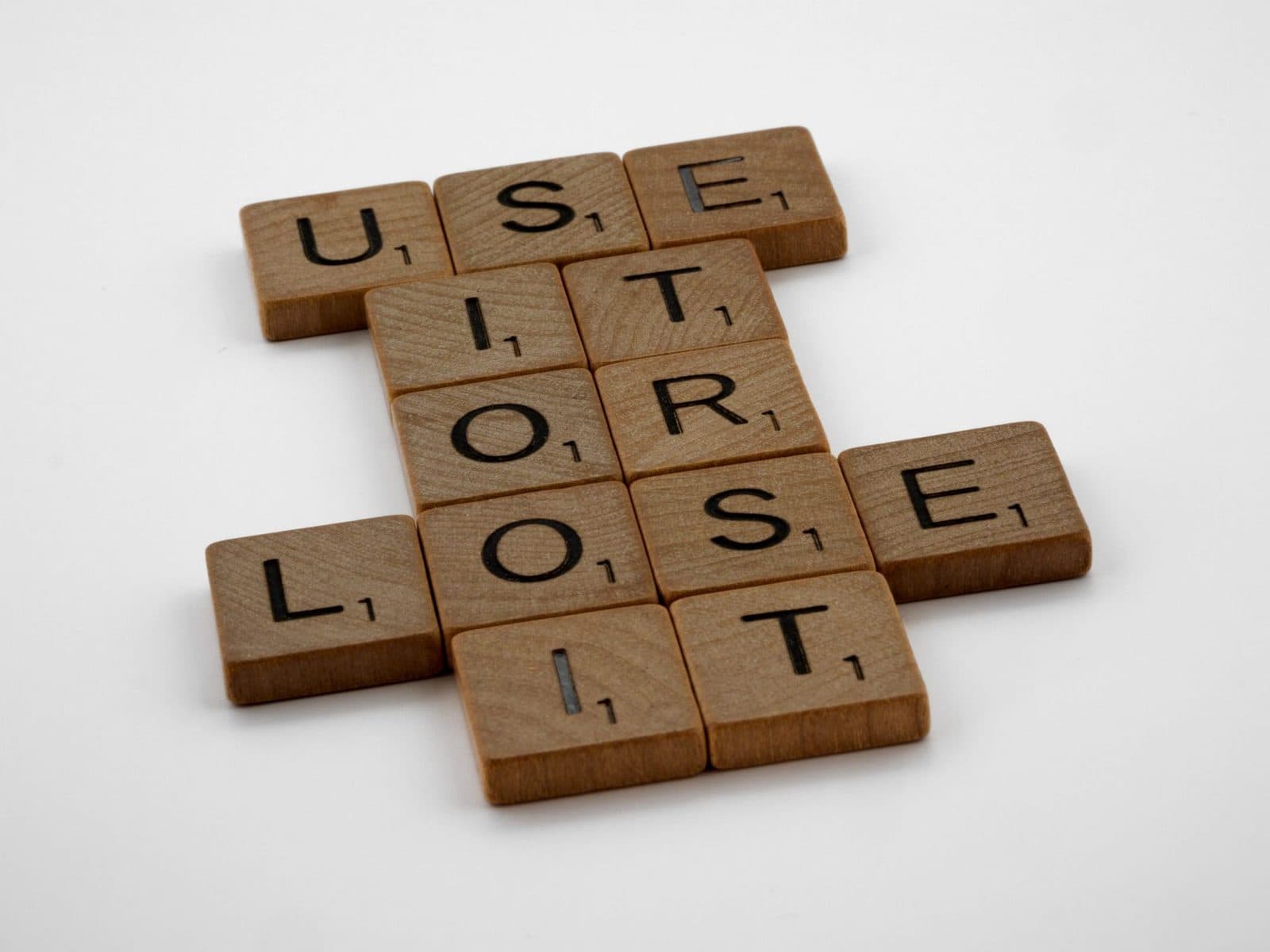 Arrangement of scrabble tiles spelling 'use it or lose it', encouraging motivation and creativity.