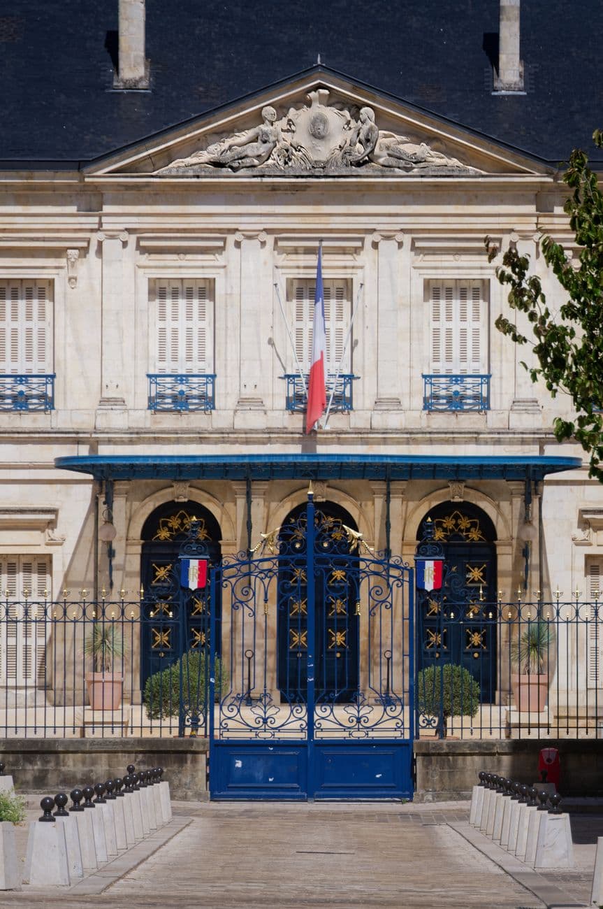 Beautiful façade of a French administrative building in Niort, France with tricolor flags.