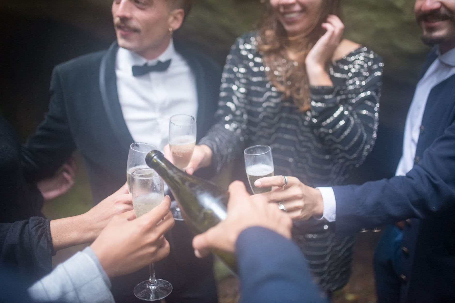 A lively group celebrates with a champagne toast outdoors, capturing joy and togetherness.