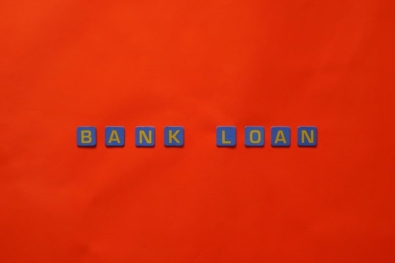 Letters forming 'Bank Loan' on a vibrant red surface, ideal for finance themes.