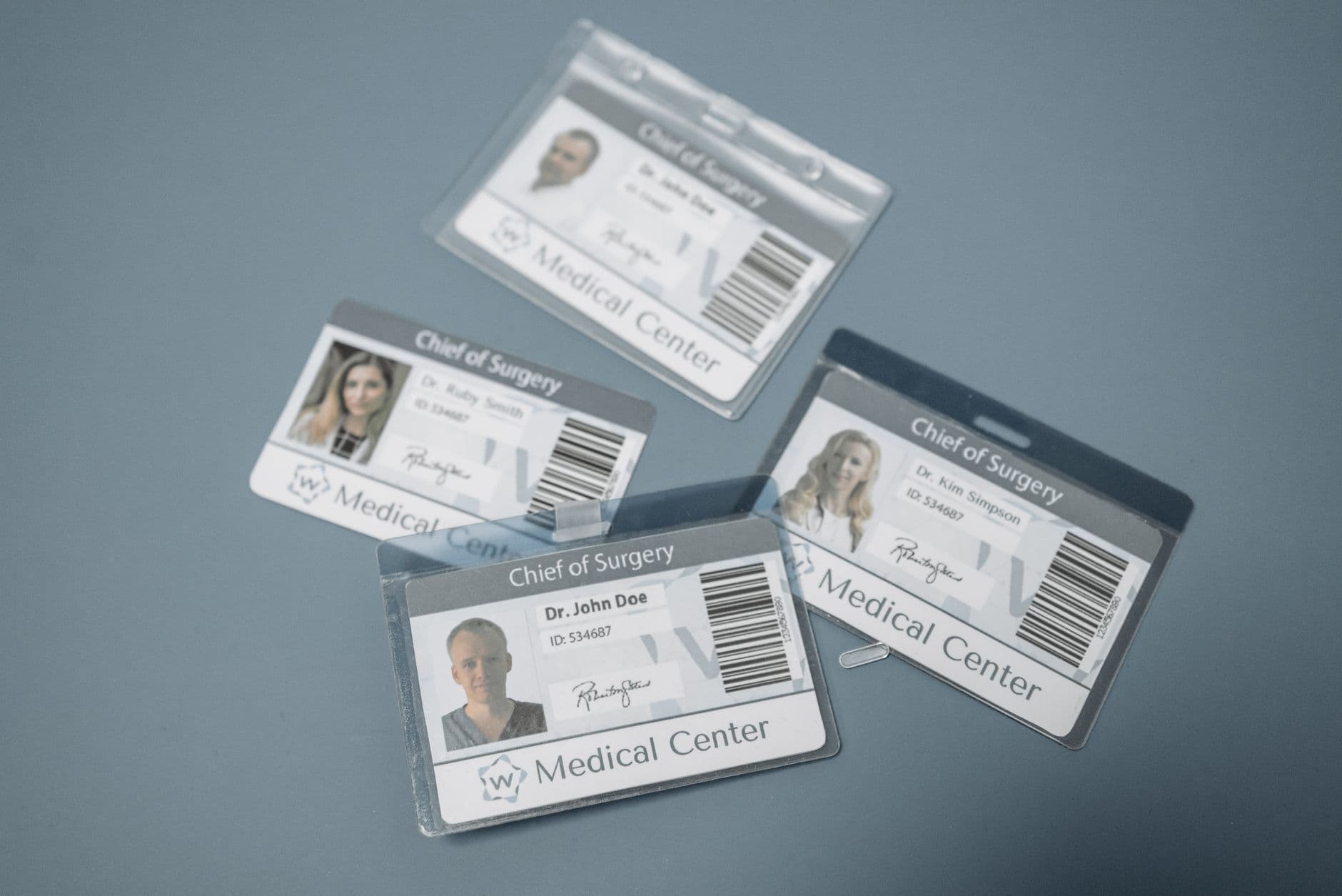High-angle view of medical ID badges for chief surgeons on a gray surface.