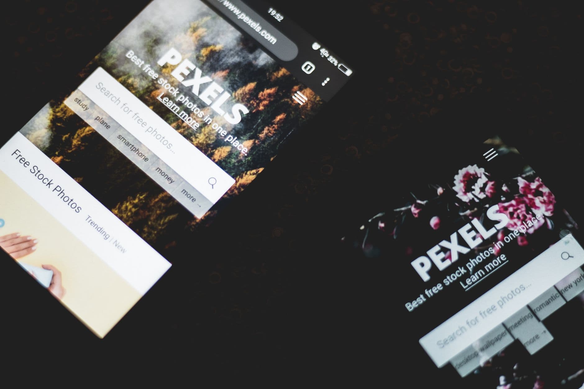 Close-up of smartphones displaying Pexels stock photo website, showcasing modern technology.
