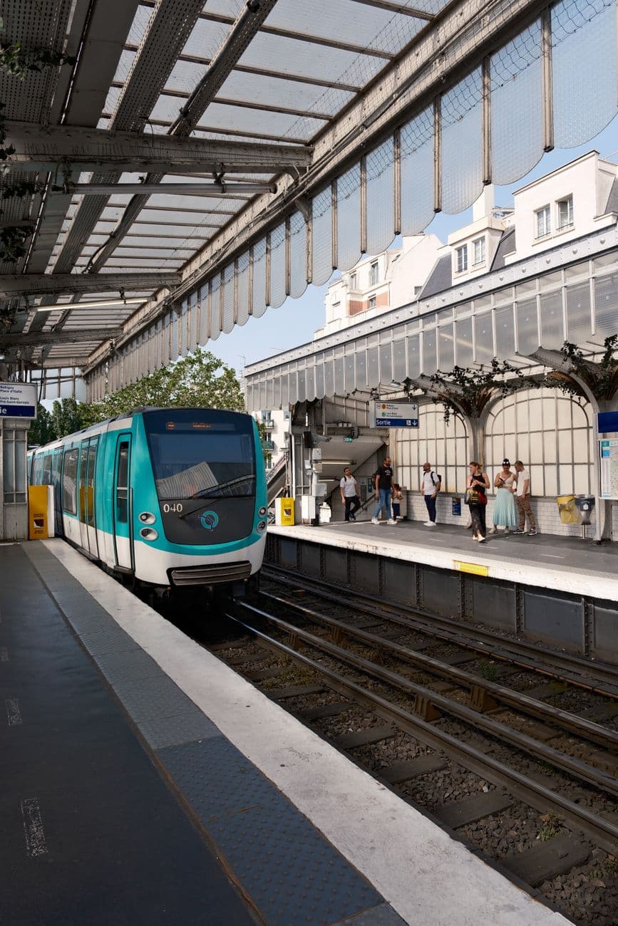 A Paris metro train arrives at an elevated station, capturing urban transit life in Île-de-France.