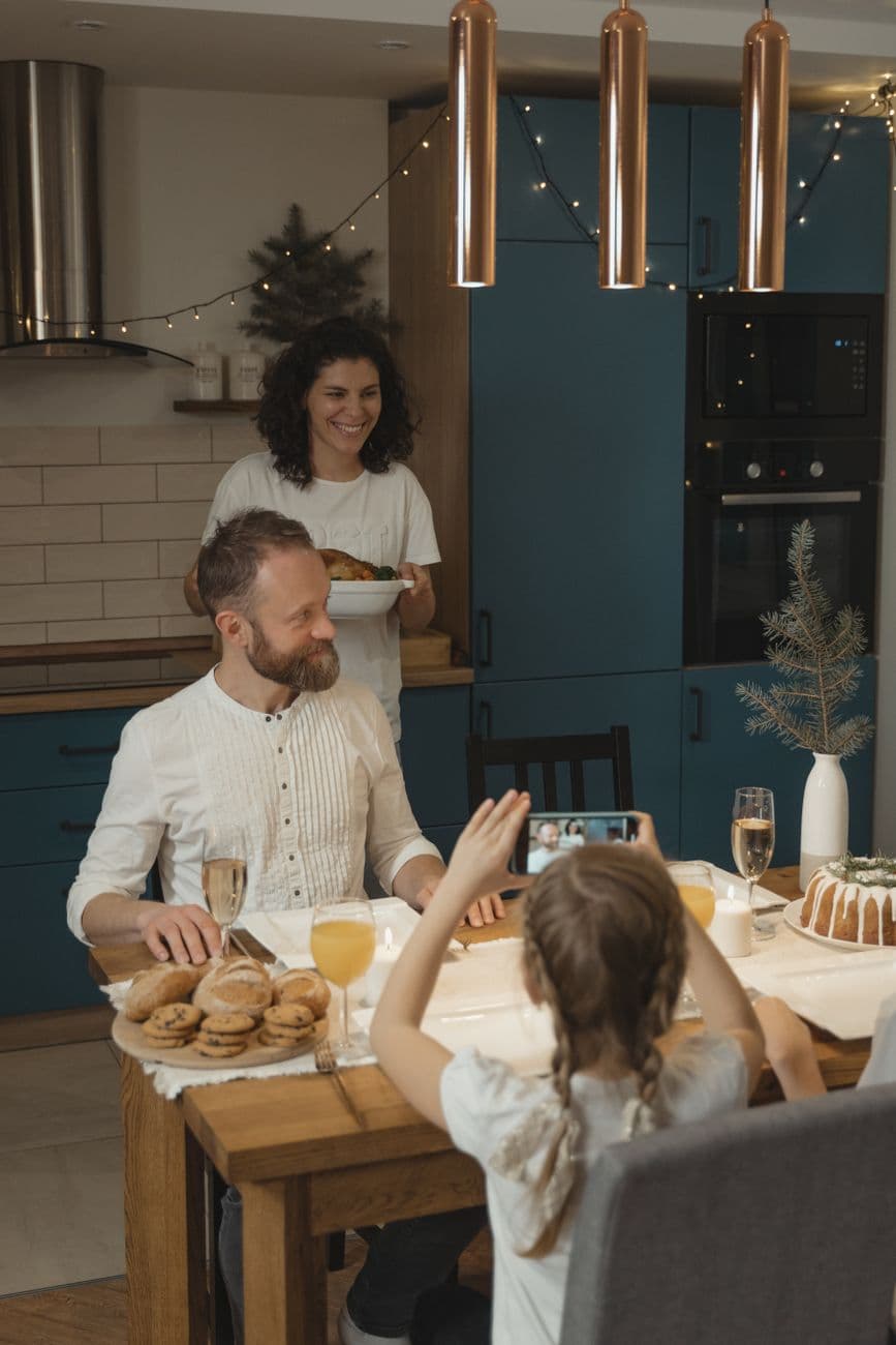 A joyful family gathering, celebrating with a festive holiday meal indoors.