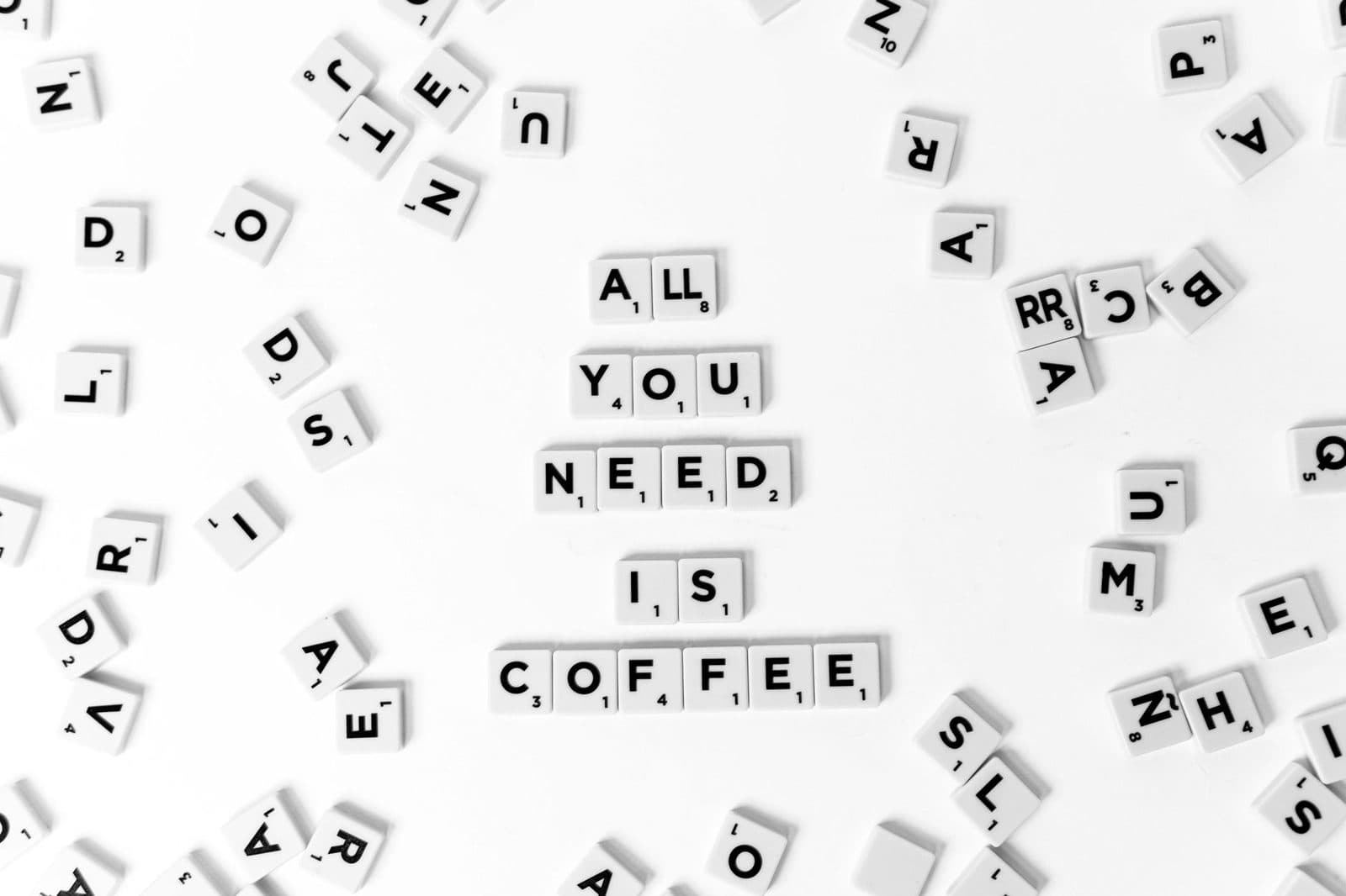 An inspiring coffee-themed text displayed with Scrabble tiles on a white background.