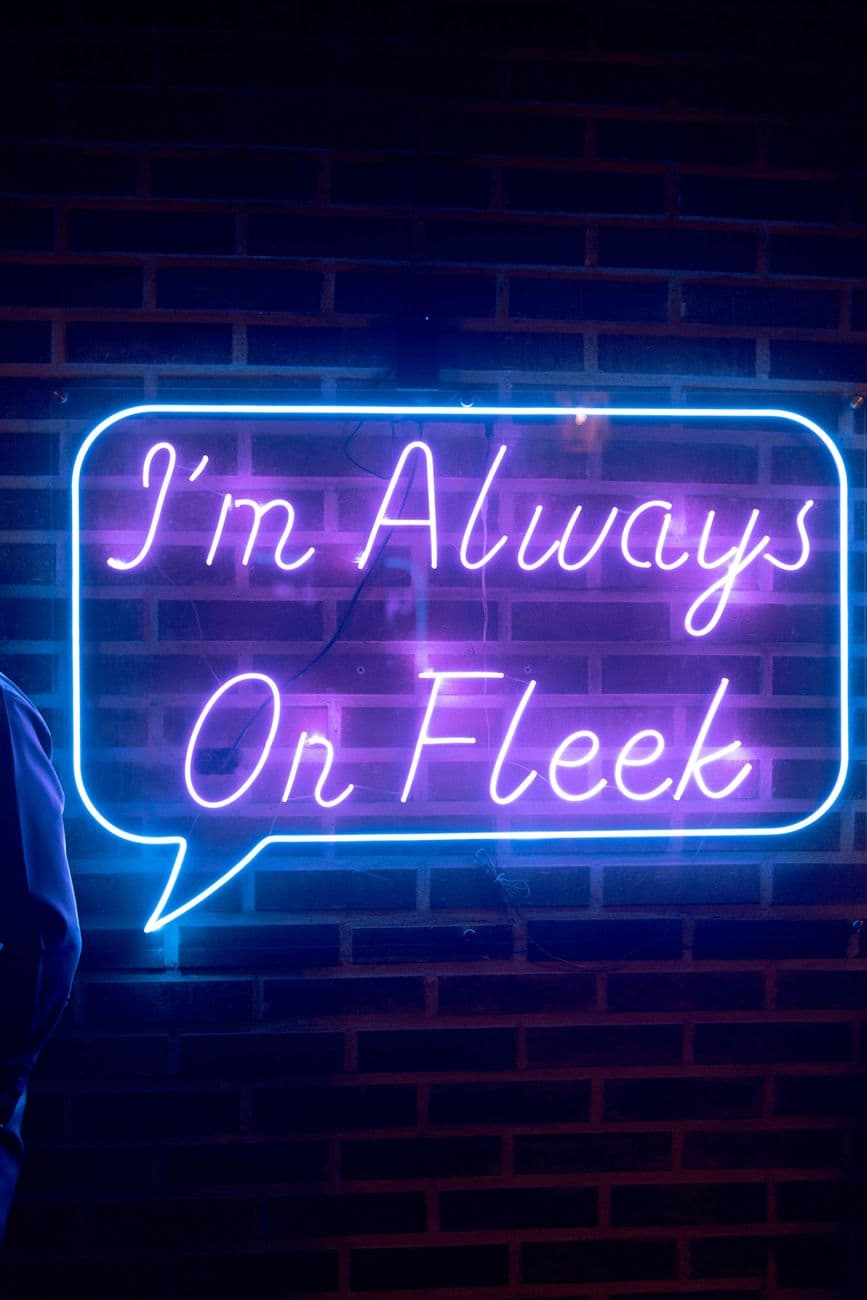 Colorful neon sign displaying trendy slang 'I'm Always On Fleek' in Abuja, Nigeria.