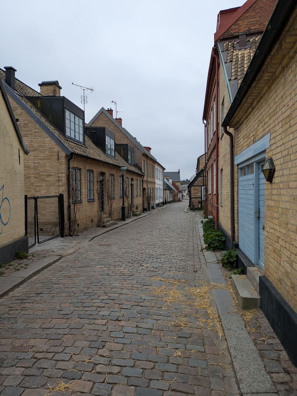 Cobblestone street in a quaint European old town with traditional buildings lining the way.
