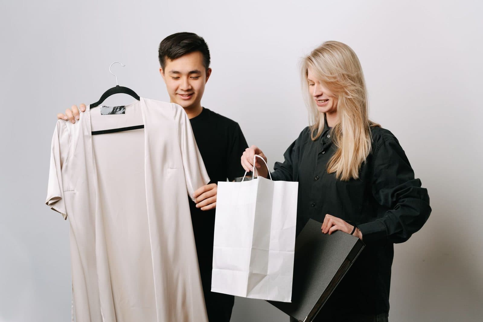 A young couple enjoys shopping while showcasing trendy clothes and bags.