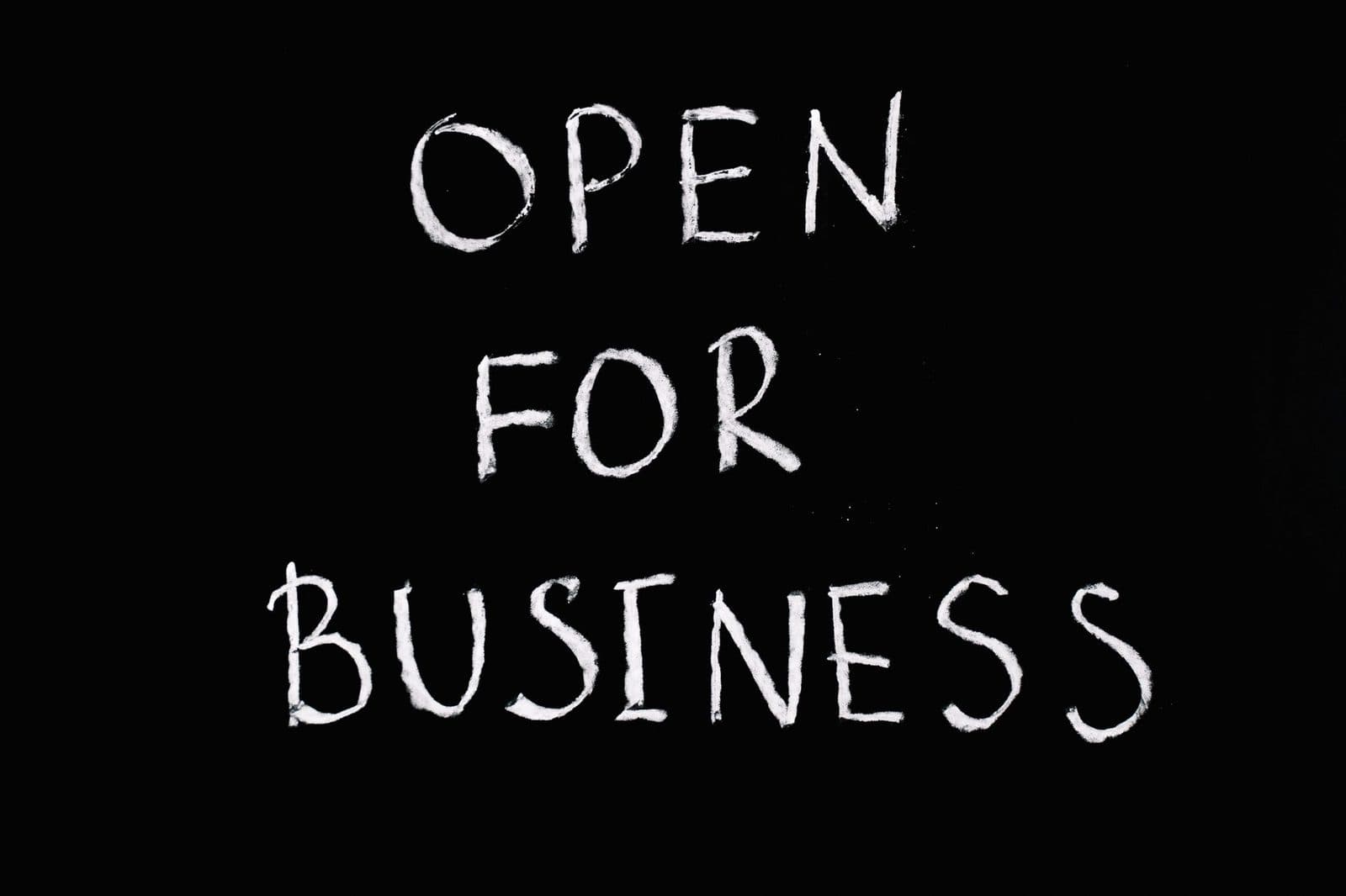 Chalkboard with 'Open for Business' text in white chalk on black background.