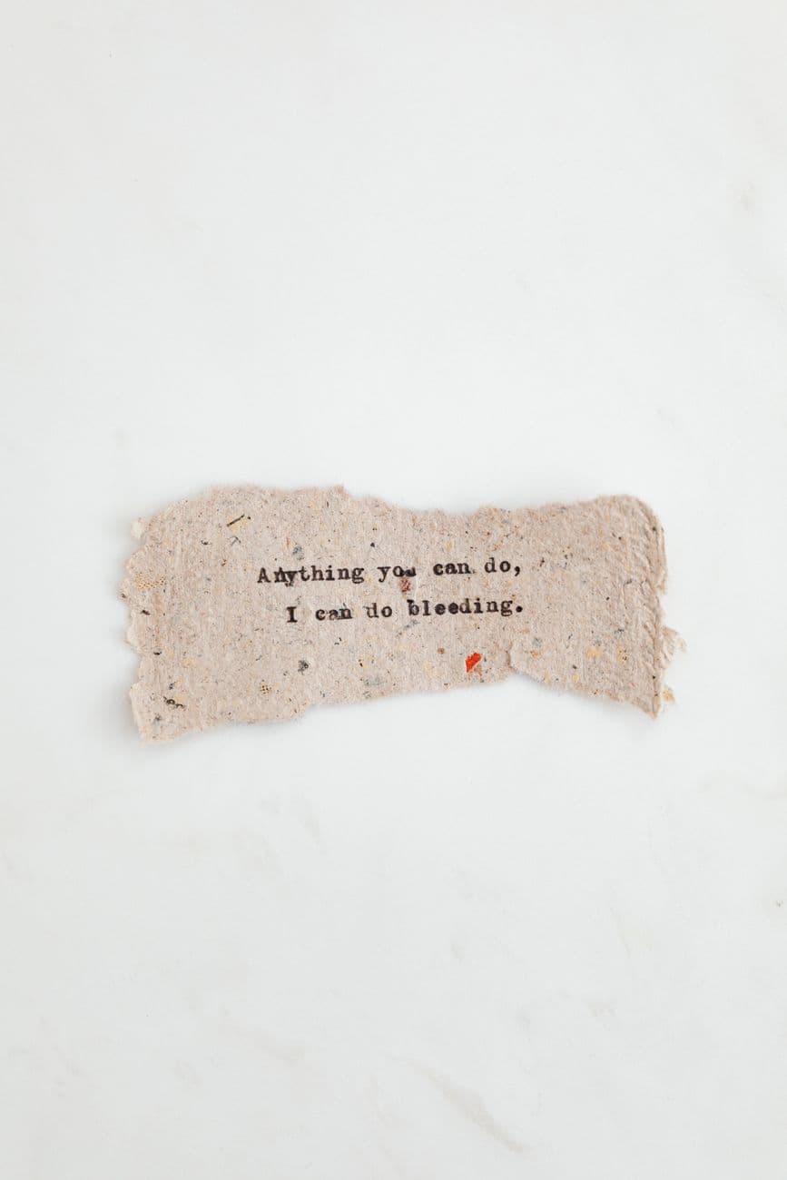 Hand-typed inspirational quote on a textured paper with a minimalist background.