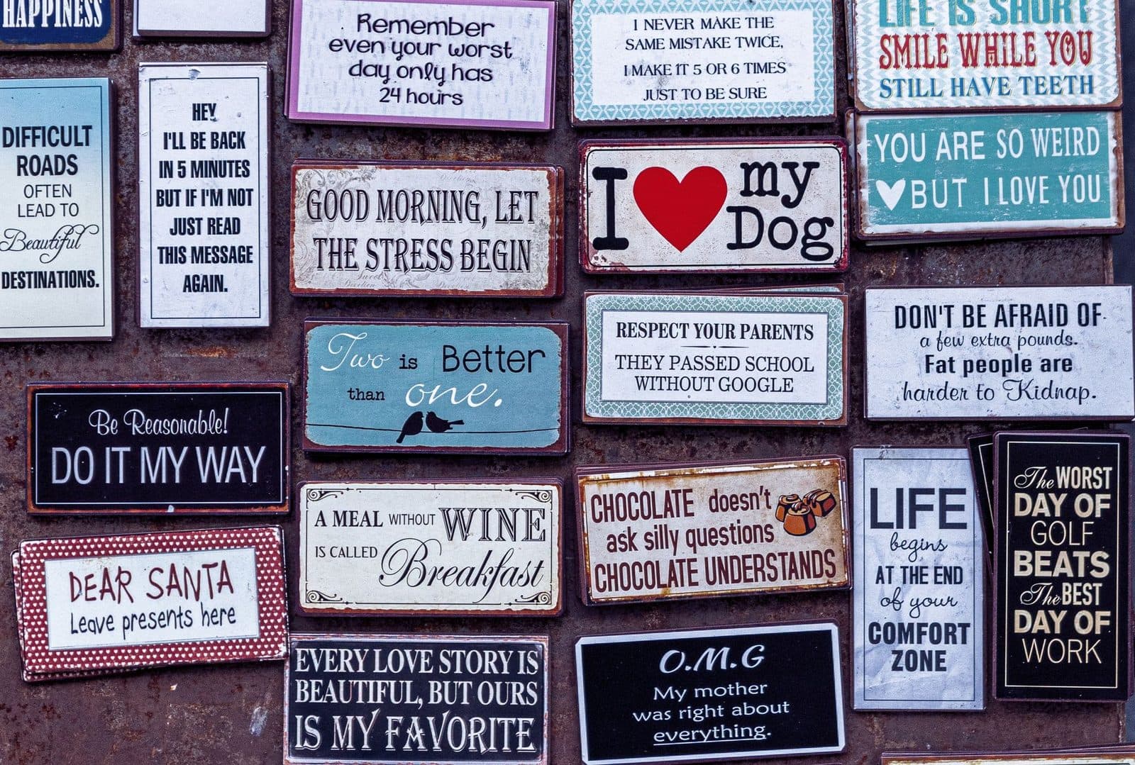 A collage of humorous and motivational retro-style wall signs displaying various messages.
