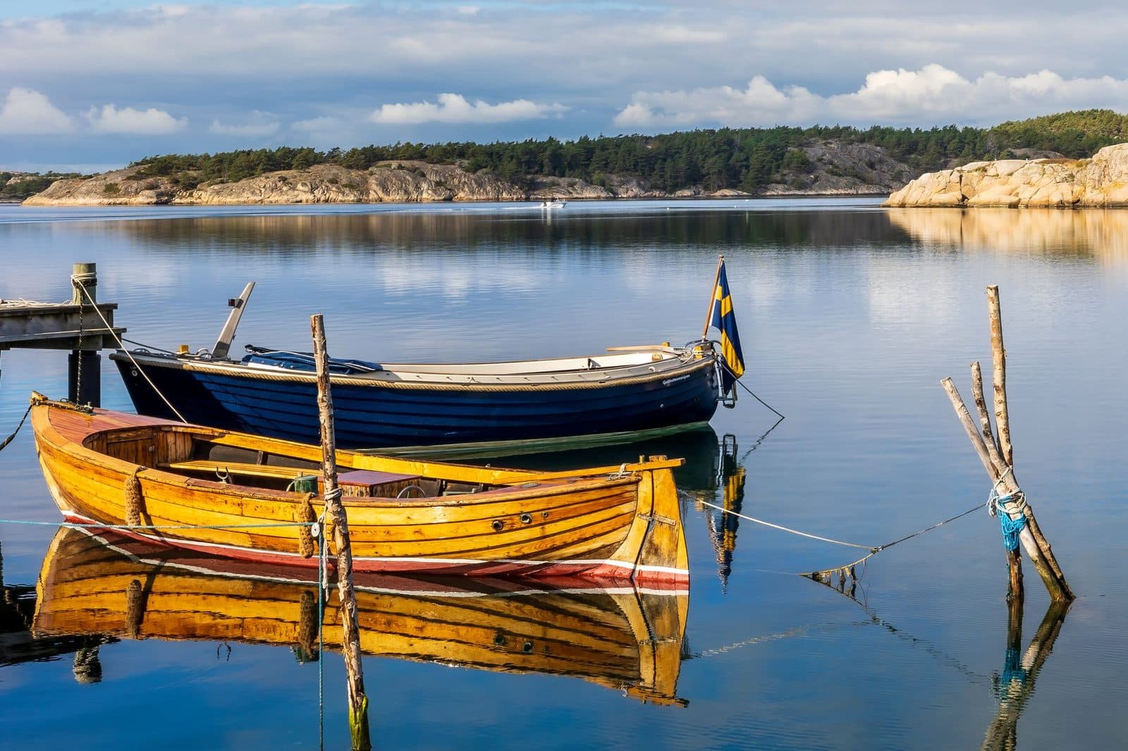Vibrant wooden boats moored in the tranquil waters of Havstenssund, Sweden, reflecting a serene coastal scene.