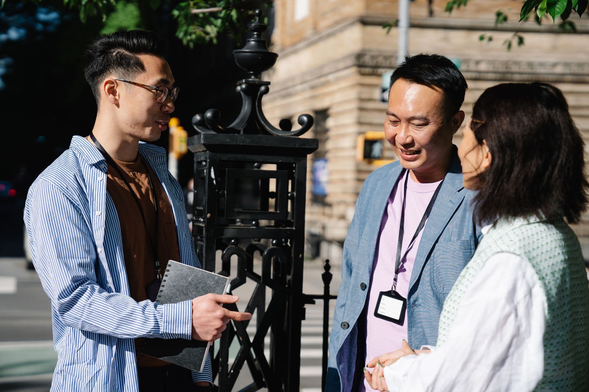 A group of colleagues engaging in a business discussion outdoors on a sunny day.