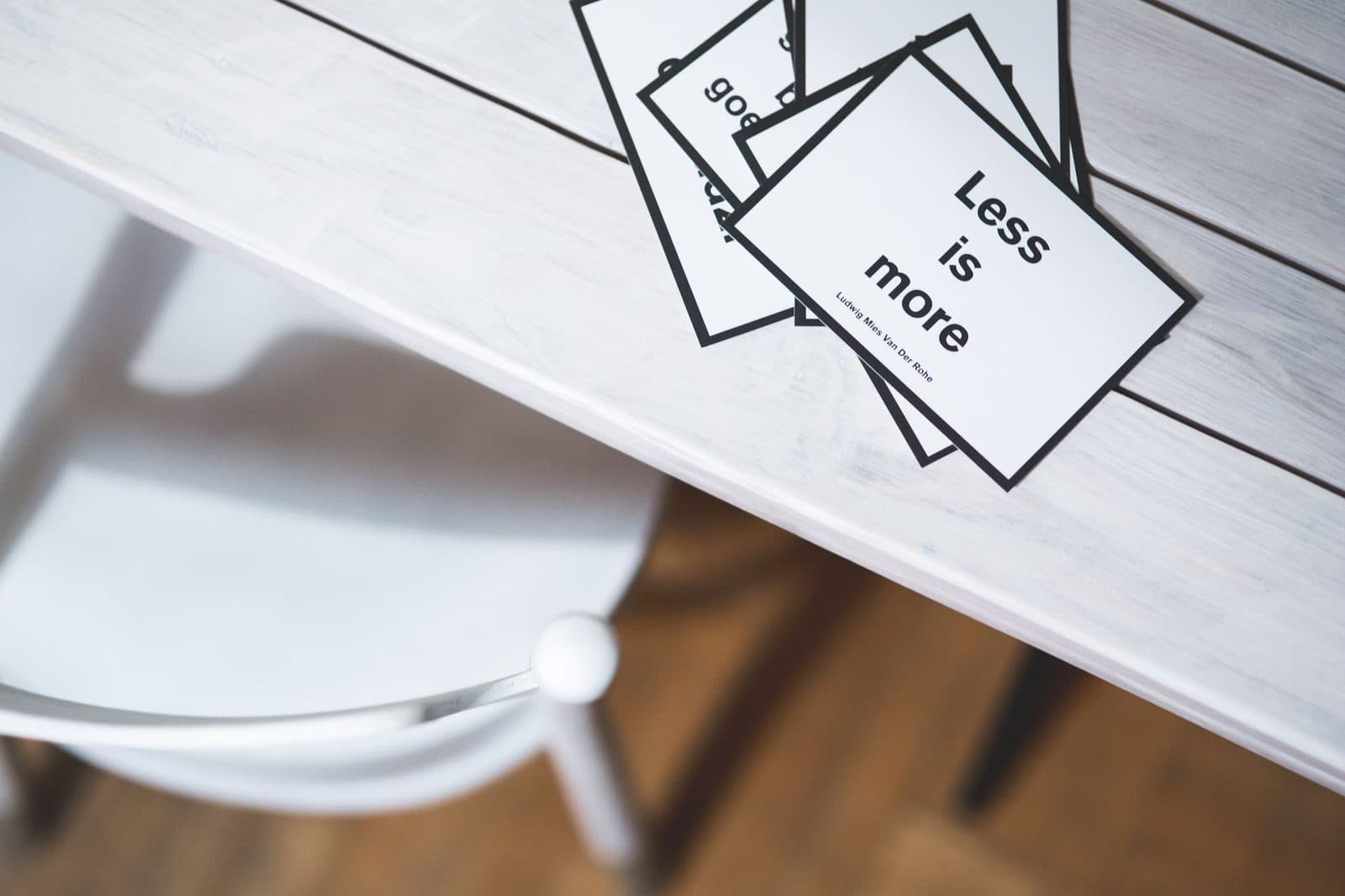 Minimalist black and white quote cards on a light wooden desk, perfect for design concepts.